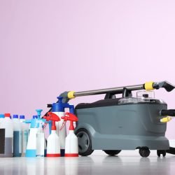 Vacuum cleaner and detergents on floor against color wall